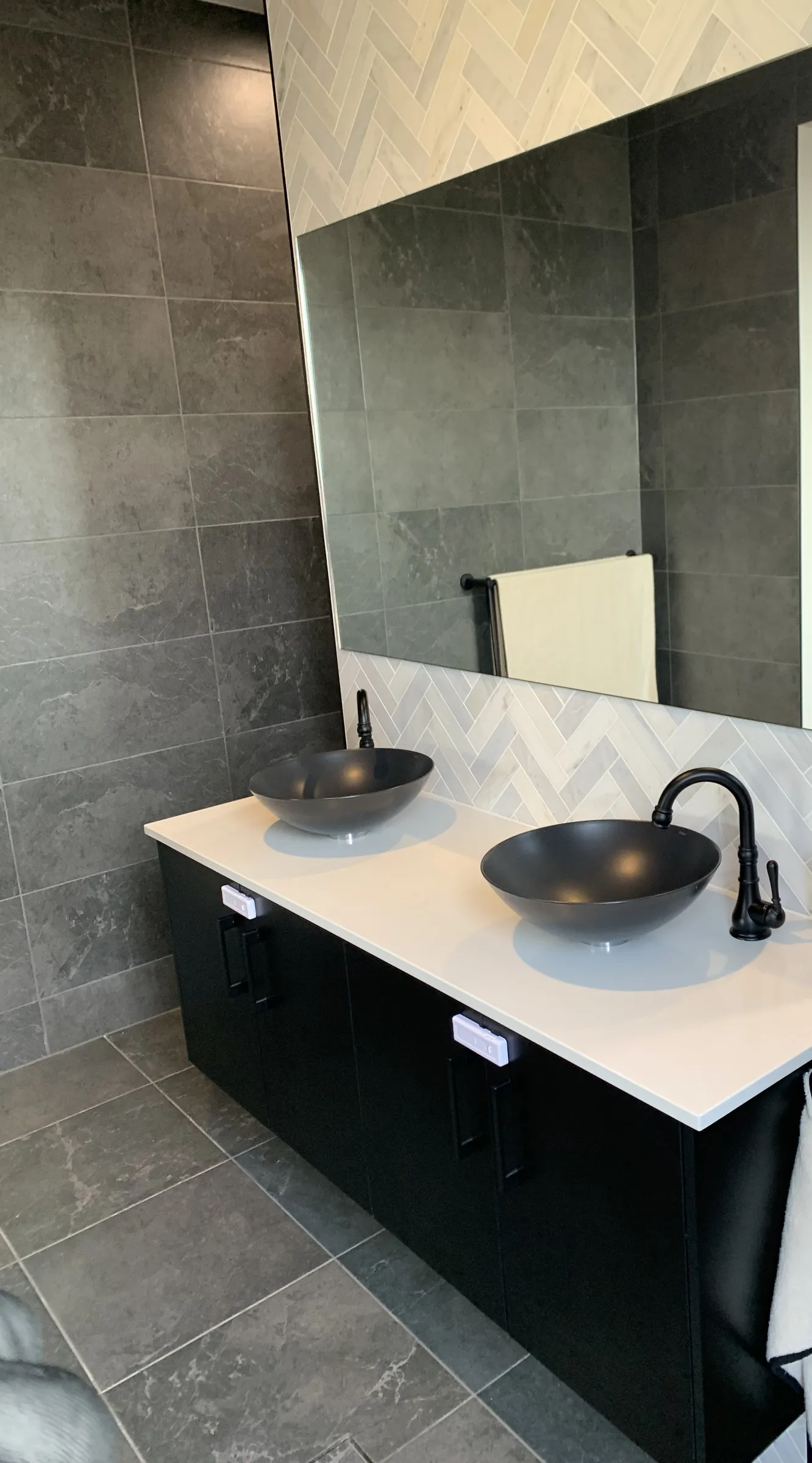 Double bathroom vanity with black vessel basins and a large mirror after cleaning