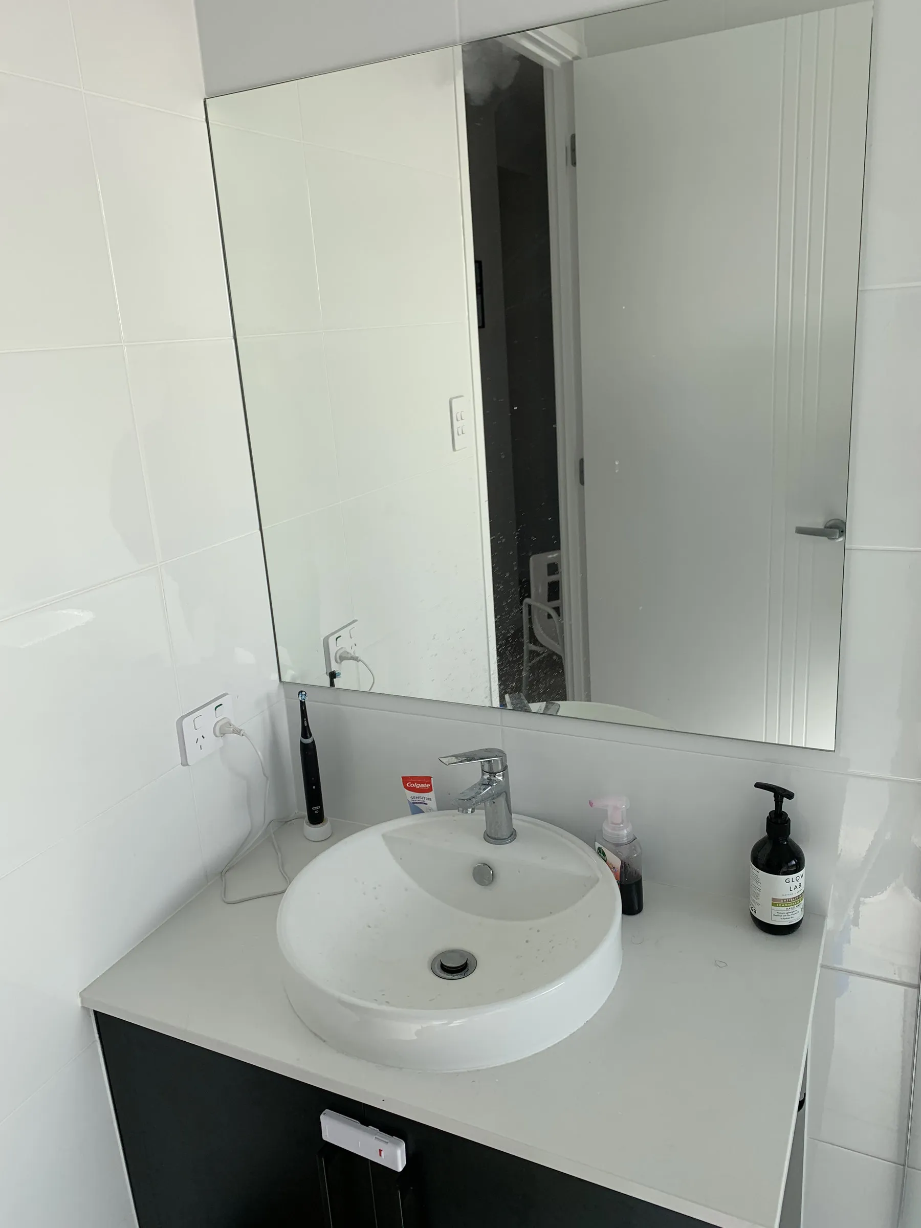 Bathroom vanity and mirror with water spotting before cleaning