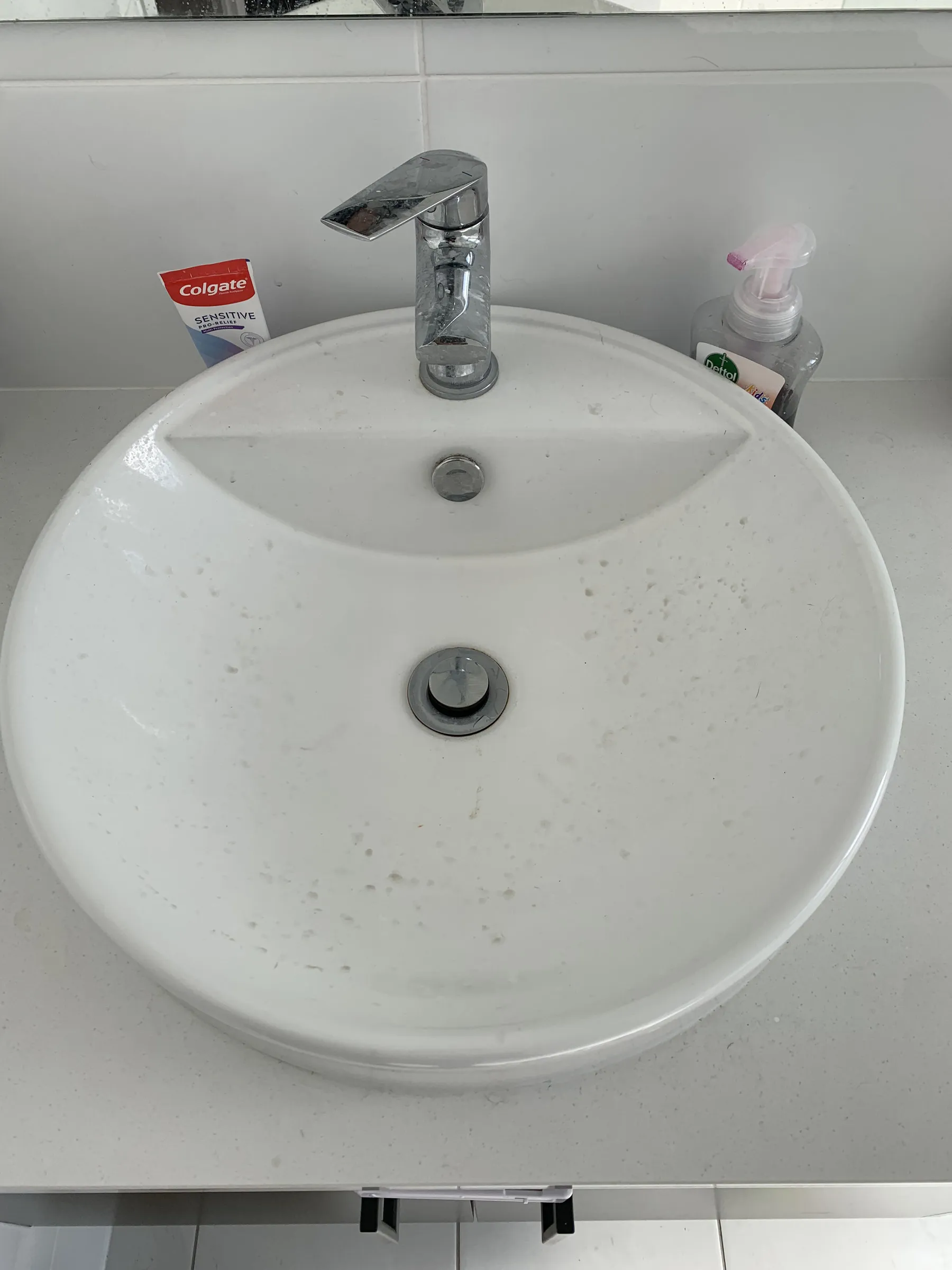Bathroom basin with toothpaste splashes and staining before cleaning