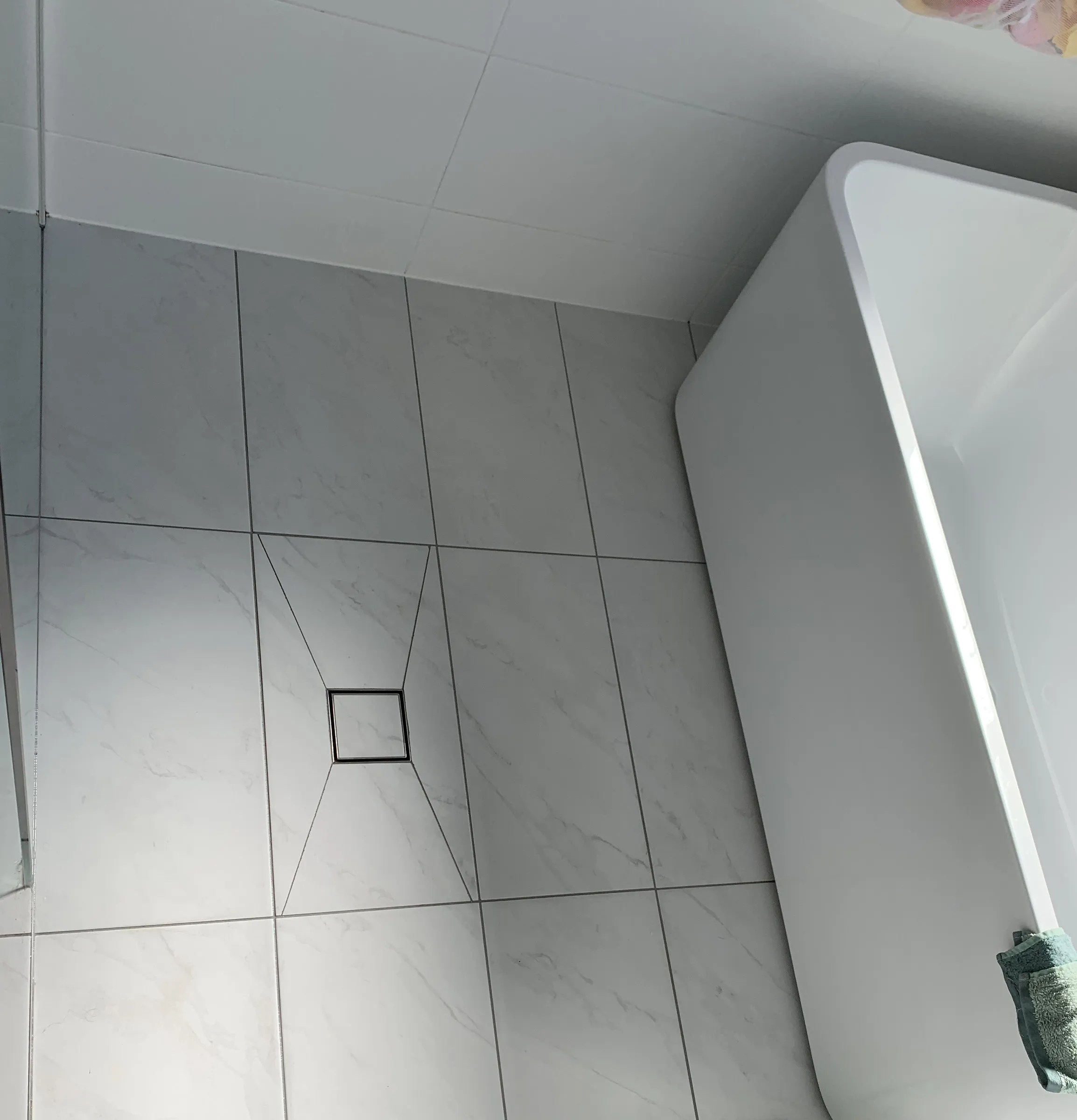 The same bathroom floor after cleaning, with clean tiles and grout