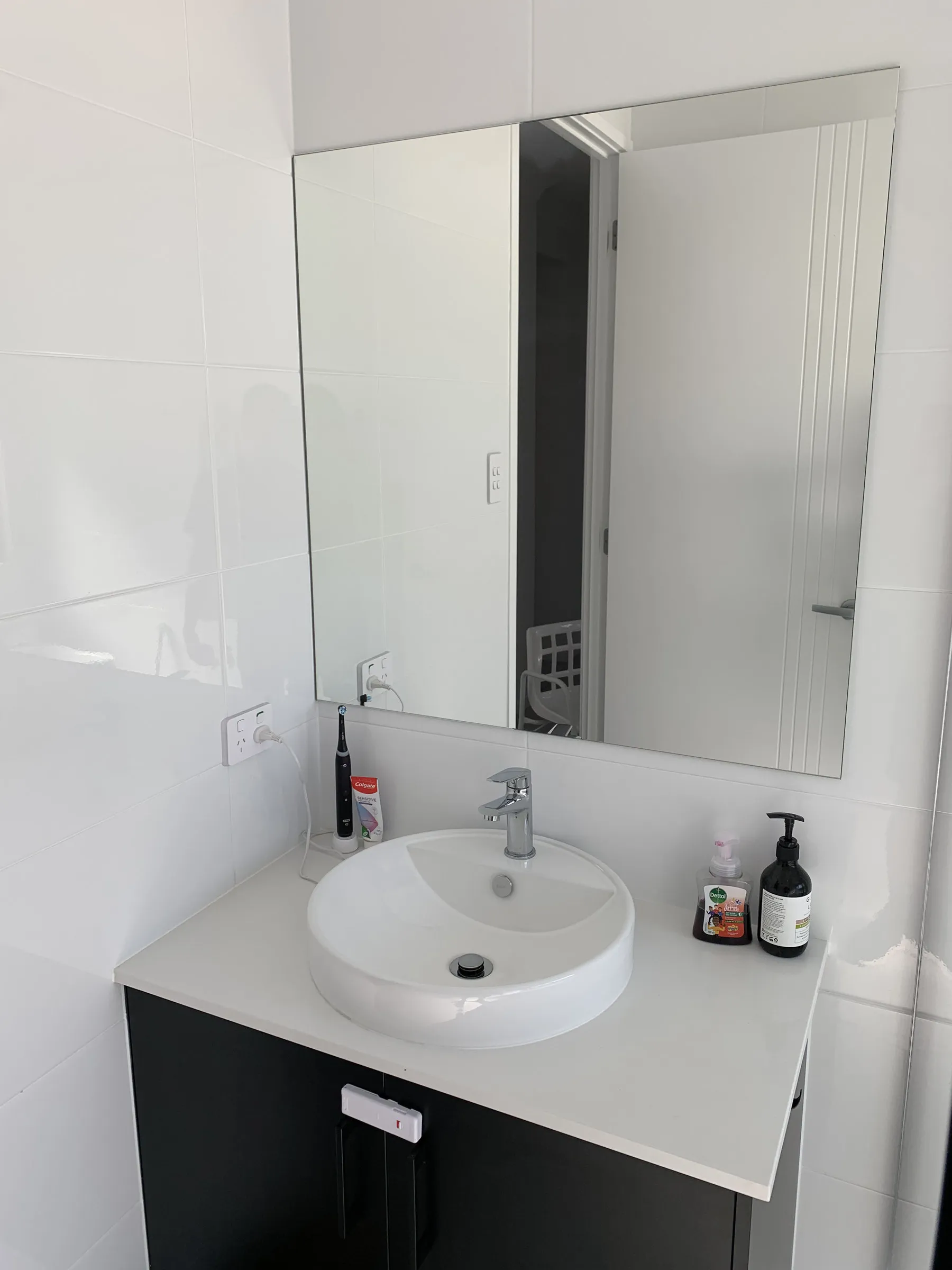 The same bathroom vanity after cleaning, with a clear mirror and clean basin