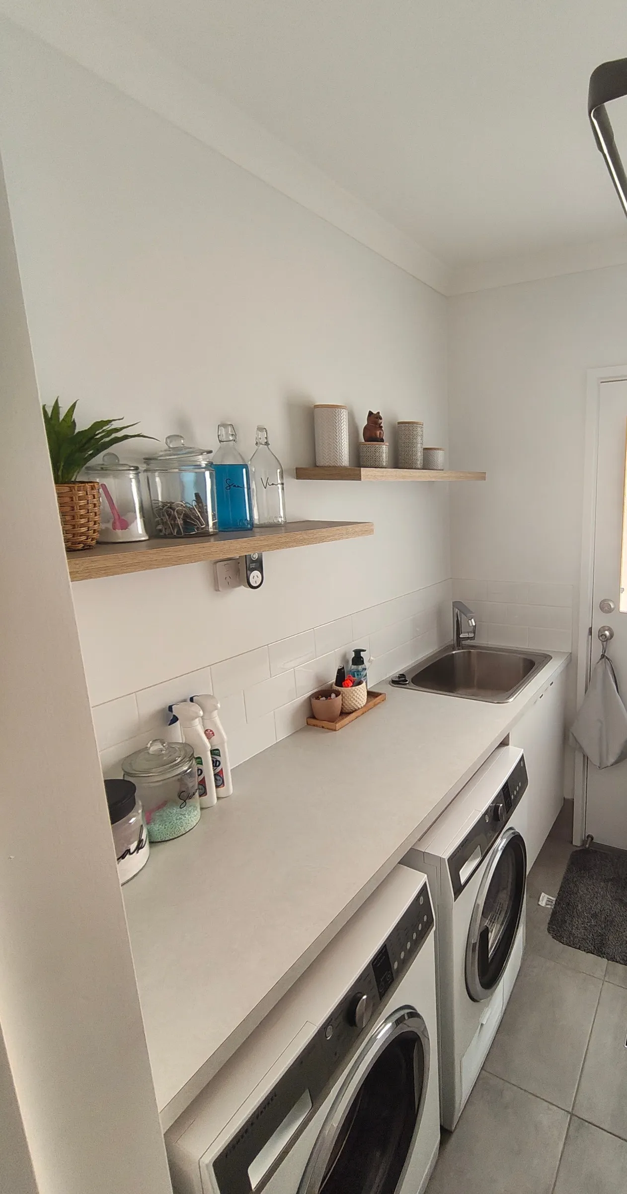 Laundry with a clear benchtop, sink and clean tiled floor